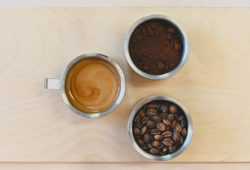 Overhead shot of coffee, beans, milk and latte on wooden table in coffee shop