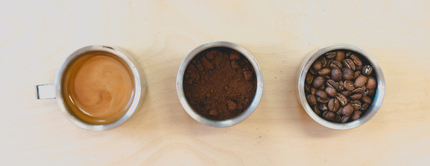 Overhead shot of coffee, beans, milk and latte on wooden table in coffee shop