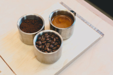 Overhead shot of coffee, beans, milk and latte on wooden table in coffee shop