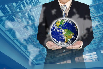 Double exposure of businessman holding planet with chart and world map on city background