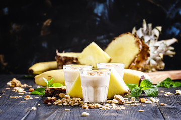 Milkshake with banana, pineapple, yogurt and muesli, selective focus