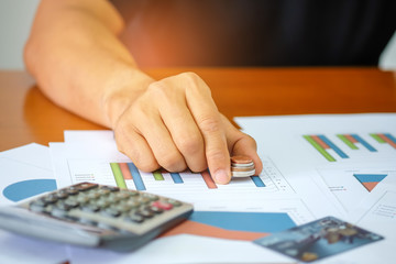 Men are using a calculator to analyze income data.