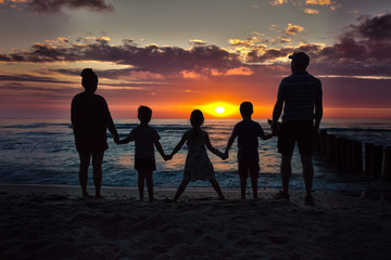 Fototapeta na wymiar Familie am Strand zum Sonnenuntergang