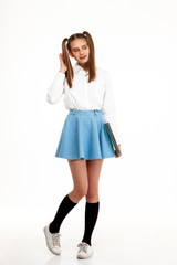 Young emotional pretty girl in uniform posing over white background.