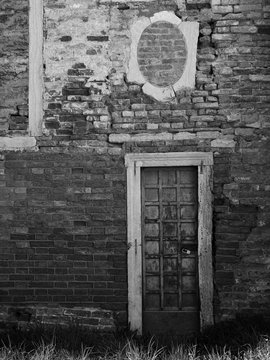 ancient brick wall with blocked windows and door