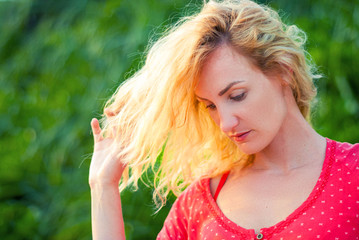 Beautiful middle-aged woman with blond hair in a red dress.