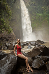 Beautiful woman in red bikini and waterfall.
