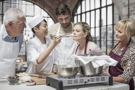 Woman smelling ingredient in cooking class