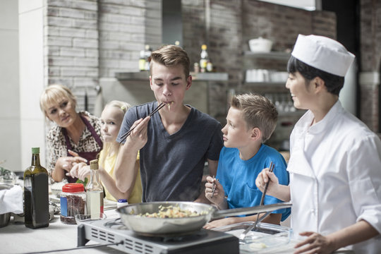 Teenager tasting meal in cooking class