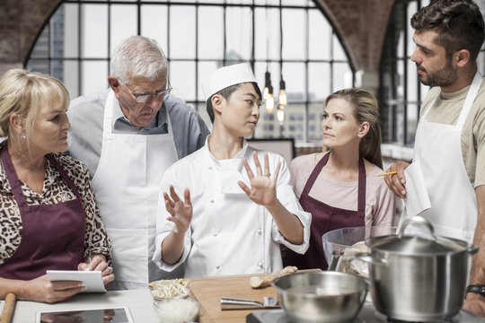 Female chef talking to students in cooking class