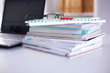 Office table with blank notepad and laptop