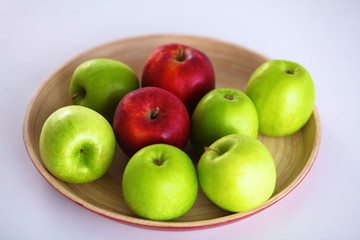 Still life arrangement of apples on a wooden platter