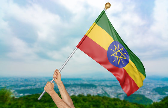 Young man's hands proudly waving the Ethiopia national flag in the sky, part 3D rendering