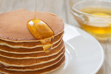 Tasty pancakes with honey for breakfast