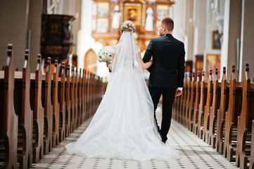 Photosession of stylish wedding couple on catholic church.