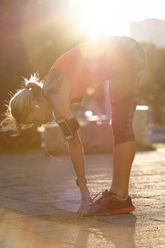 Morning jogger stretching at sunrise