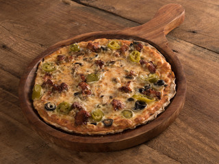 BBQ Chicken pizza served in a wooden plate on wooden background