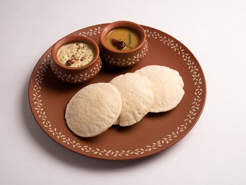 idli with sambar and coconut chutney served in a plate on white background