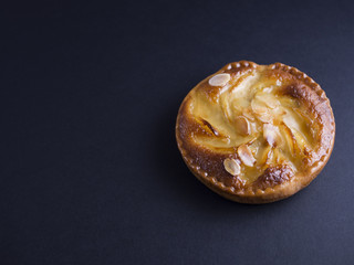Almond and pear tart isolated on black background