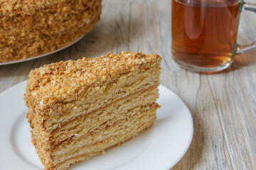 Piece of tasty cake Napoleon on wooden background