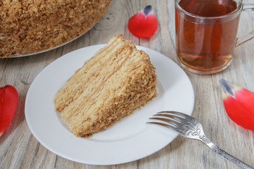Piece of tasty cake Napoleon with tea on wooden background