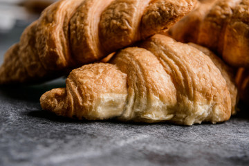 Fototapeta premium Macro picture of croissants on grey table. 