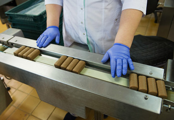 Glazed syrki with chocolate on the conveyor