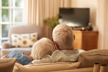 Affectionate senior couple relaxing together on their sofa at home