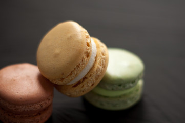 Delicious multicolored cake macaron or macaroon on black background