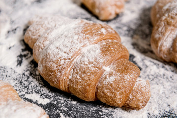 Macro picture of croissants with powdered sugar on grey table. 