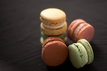 Delicious multicolored cake macaron or macaroon on black background