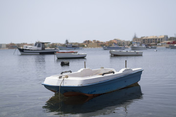 Fototapeta na wymiar A little old boat docked at the marina in Marzamemi village.