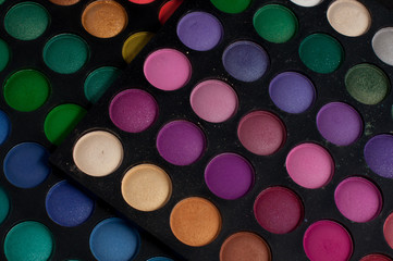 Palette of professional colorful eye shadows. Collection of multicolor eyeshadows. Makeup set background.