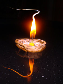 Floating Candle Burning On A Nut Shell