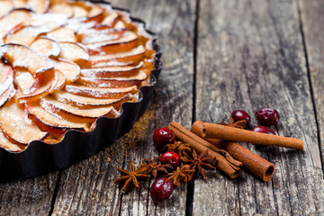 Apple pie tart on rustic wooden background. Top view.