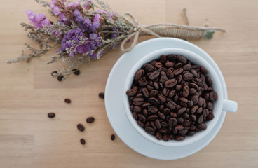 A cup of coffee beans with dry flowers