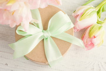 Pink tulips and gift box with green ribbon