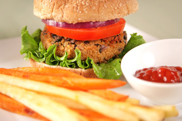 A back bean and couscous (vegan) hamburger with parsnip and sweet potato fries.
