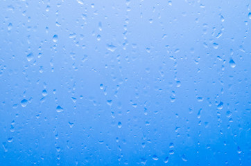 Water droplets on the glass with a colored background. Drops of water.