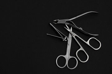 set of metallic manicure tools on a black background