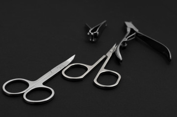 set of metallic manicure tools on a black background