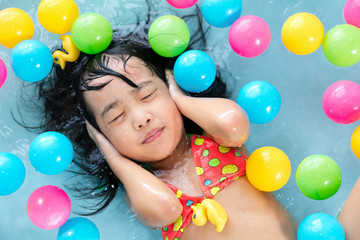 Fototapeta na wymiar Asian Chinese little girl floating in the inflatable pool