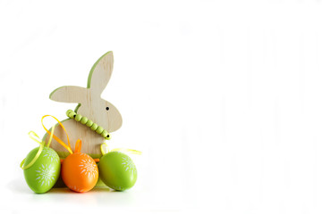 Easter, wooden rabbit and three colored eggs 1