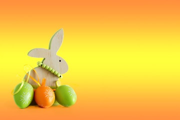 Fototapeta na wymiar Easter, wooden rabbit and three colored eggs