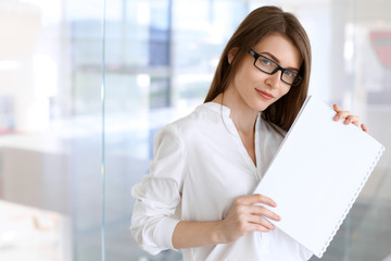 Business woman keeping copy space area while standing in the office