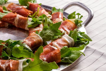 Picture of bacon rolls with arugula on white background. 