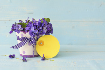 Beautiful bouquet of field violets in a small vase with empty  message card 