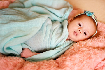 Little cute newborn baby girl in the bed