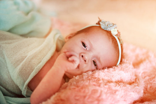Little cute newborn baby girl in the bed