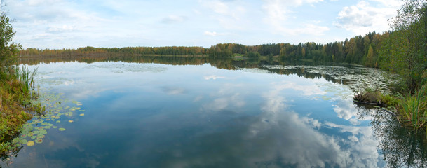 Fototapeta premium Panorama of Svetloyar Lake with forest along bank reflecting in calm water. Nizhegorodsky region, Russia 